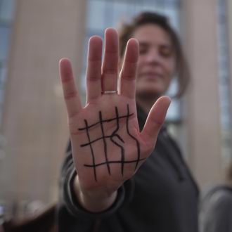 Lady holding her hand up with the End the Cage Age logo drawn on her palm.